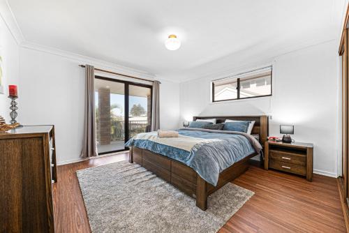 a bedroom with a bed and a window at Spacious Ocean View Home in Noraville in Norah Head