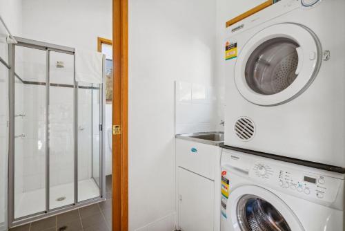 a laundry room with a washer and dryer at Nowhere Chalet in Crackenback