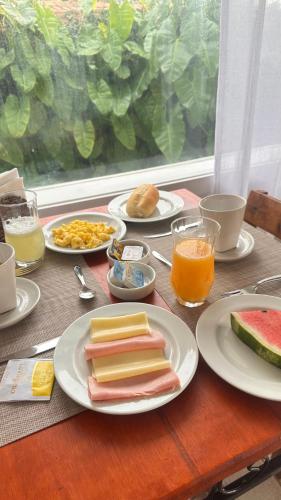 een houten tafel met borden met eten erop bij Bossa Nova Búzios Pousada Home in Búzios