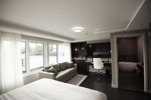 a bedroom with a bed and a couch and a desk at the reid hotel in Vanderhoof
