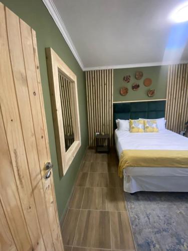 a bedroom with a bed and a wooden door at Kanana Villas in Maun