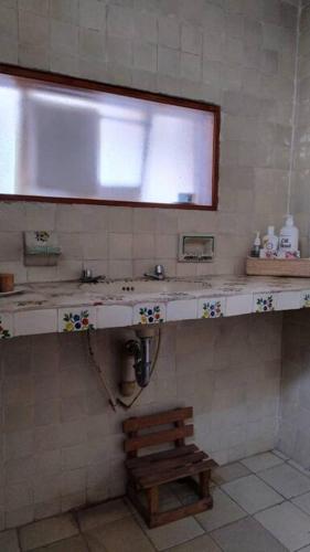 a bathroom with a sink and a wooden bench at Linda Casa en Tepoztlan centro 1 in Tepoztlán