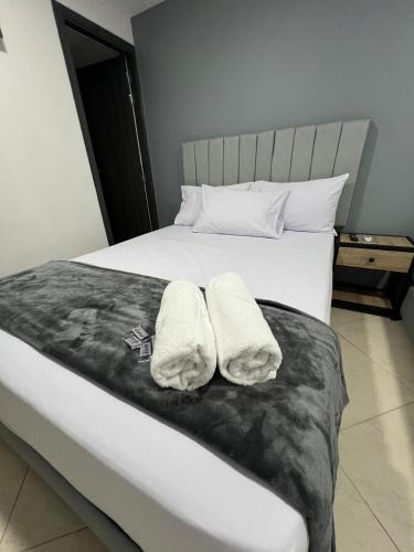 a bedroom with a bed with two towels on it at Hotel Casa Florida 70 Medellin in Medellín