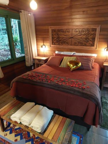 a bedroom with a bed with a wooden wall at Chalés Serras House Casa Verde e Casa Laranja in São Francisco de Paula