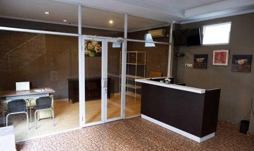 una camera con porte in vetro, tavolo e scrivania di Gaing Mas Residence By Gaing Mas Group a Jimbaran