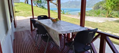 a table and chairs on a porch with a view at Bungalow Belle Vue in Maroe