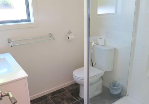 ein weißes Badezimmer mit Toilette und Waschbecken in der Unterkunft Alpine Nook in Lake Tekapo