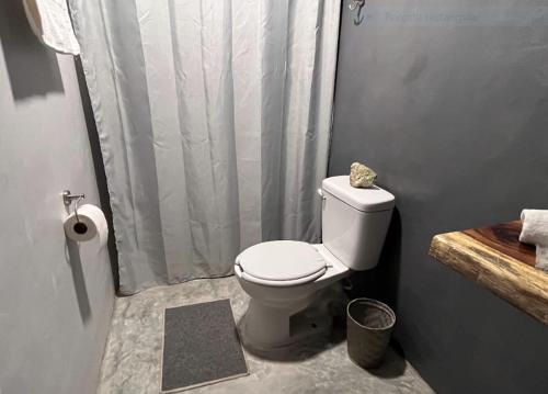 a bathroom with a toilet with a shower curtain at Casa Ik en Coba in Cobá