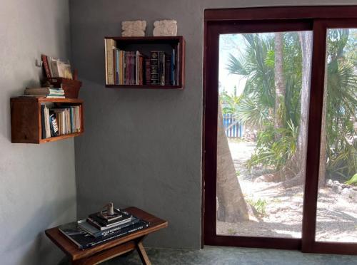a room with a window and a table with books at Casa Ik en Coba in Cobá