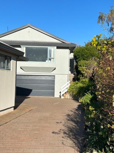a house with a garage and a brick driveway at Guest Suite - Walk to Havelock North Village in Havelock North