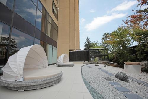 a building with two chairs in front of a building at Aburaya Tousen in Yamanouchi