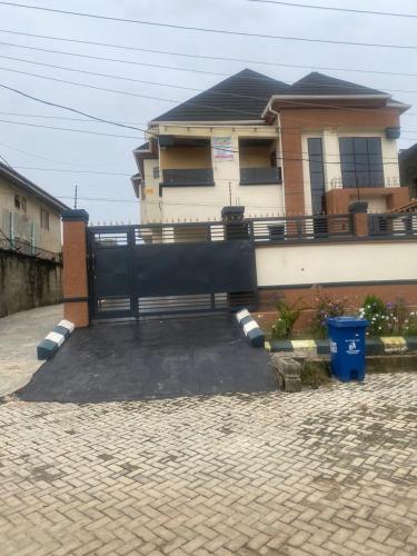 a house with a black fence in front of a driveway at MAlMATMANN CONFORT in Pakuro