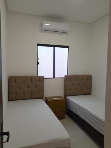 a bedroom with two beds and a window at Casa em Petrolina otima localização in Petrolina