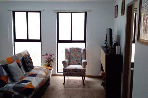 a living room with a couch and a chair and windows at Central and cozy apartment in Mexico City