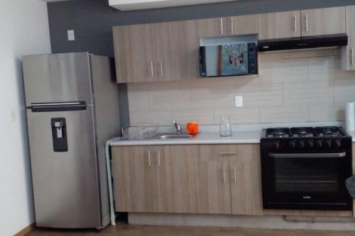 a kitchen with a stainless steel refrigerator and a sink at Central and cozy apartment in Mexico City