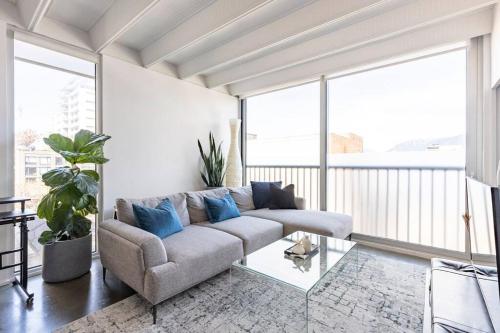 a living room with a couch and a glass table at Cozy 1BR with AC, Chinatown, Rogers Arena, Seawall in Vancouver