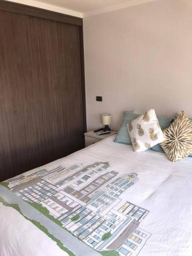 a bed with two pillows on top of it at Departamento frente a Casino Enjoy in Coquimbo