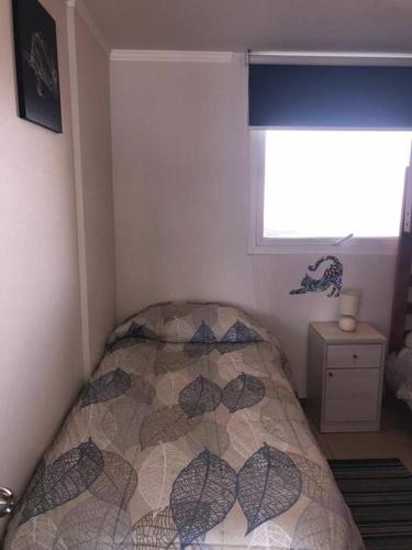 a small bedroom with a bed in a corner at Departamento frente a Casino Enjoy in Coquimbo