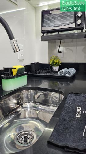 a kitchen counter with a sink and a microwave at Copacabana Vibes Studios in Rio de Janeiro