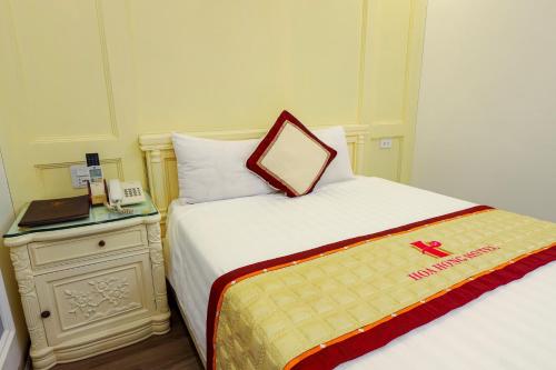 a hotel room with a bed and a night stand at Hoa Hong Hotel - Xa Dan in Hanoi