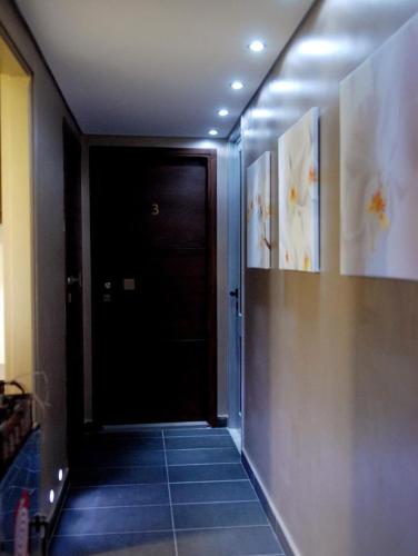 a hallway with a black door and a tile floor at Grimani Pension in Nafplio