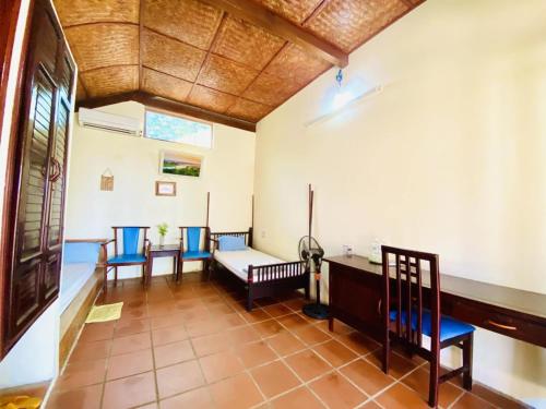 a room with two beds and a table and chairs at Tam Thanh Natural Beach Resort in Tam Ky