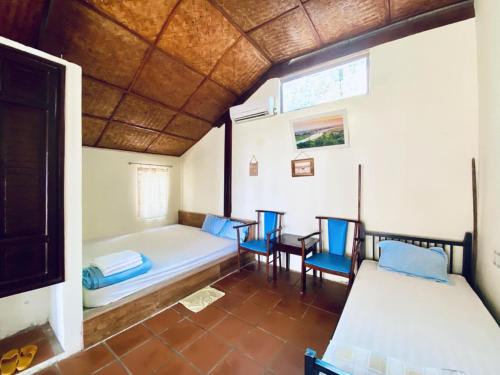 a room with two beds and a table and chairs at Tam Thanh Natural Beach Resort in Tam Ky
