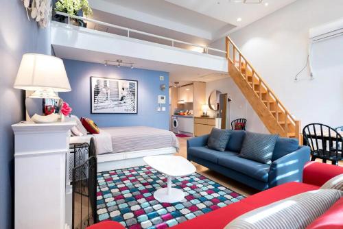 1 dormitorio con cama, sofá y escalera en Oasis Hongdae City View, en Seúl