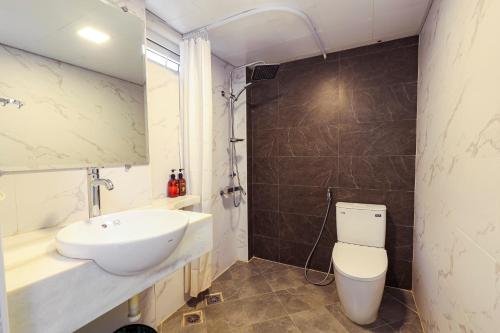 a bathroom with a white toilet and a sink at Hoa Hong Hotel - Xa Dan in Hanoi