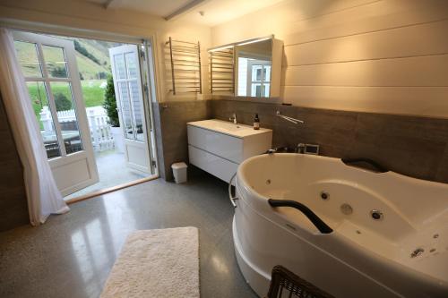 a bathroom with a tub and a sink and a mirror at Alnes Gård in Ålesund