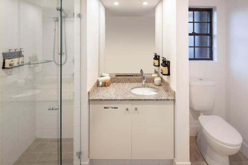 a bathroom with a toilet and a sink and a shower at Peppers The Hills Lodge in Castle Hill