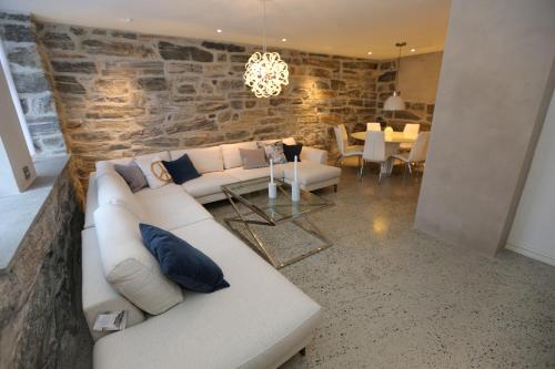 a living room with a white couch and a stone wall at Alnes Gård in Ålesund