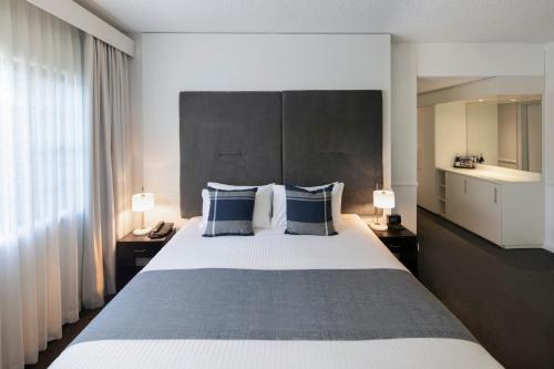 a bedroom with a large bed with blue pillows at Peppers The Hills Lodge in Castle Hill