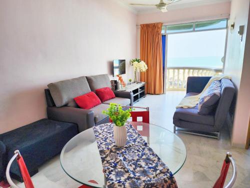 ein Wohnzimmer mit einer Couch und einem Glastisch in der Unterkunft Glory Beach Resort PD, Fully Aircon Beatiful View Suite PortDickson in Port Dickson