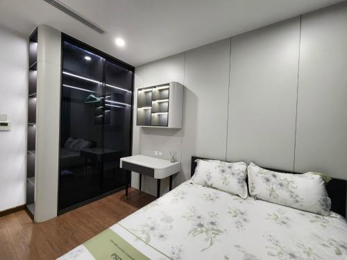 a small bedroom with a bed and a sink at The Matrix One Căn Hộ 3 Phòng Ngủ Tiện Nghi. in Hanoi