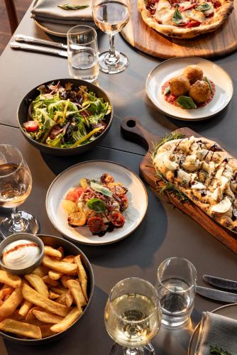 a table with plates of food and glasses of wine at Cleveland Estate in Lancefield