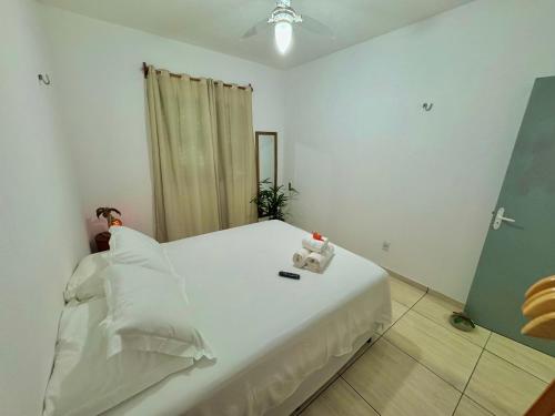 a bedroom with a white bed with two teddy bears on it at Casa Praia Beira Mar "TÉRREO" Guriú,Ce in Guriú