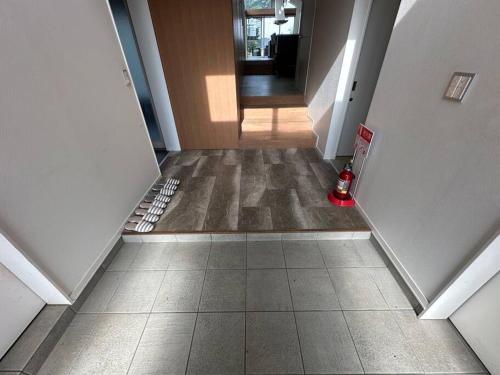 a hallway with a tile floor with a fire hydrant on it at Mahalo Ichinomiya in Ichinomiya