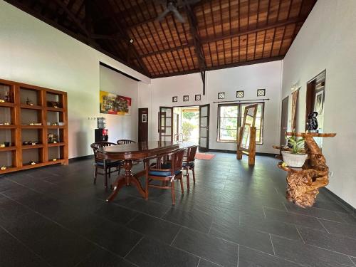 a dining room with a wooden table and chairs at Bale Solah Lombok Holiday Resort in Senggigi 
