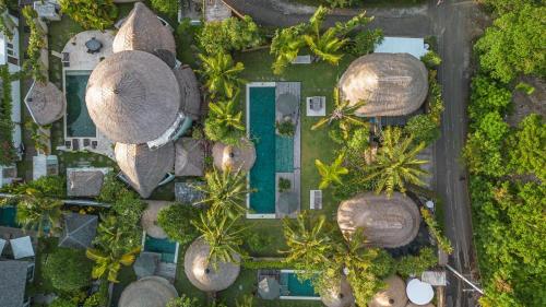 an overhead view of a resort with palm trees and a pool at Acacia Bungalows Bingin in Uluwatu