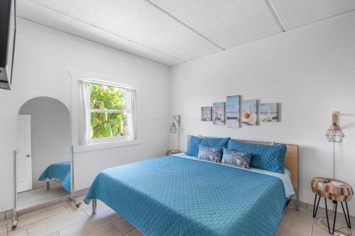 a bedroom with a blue bed and a window at SPI Beach Condo - Just a block away to Paradise in South Padre Island