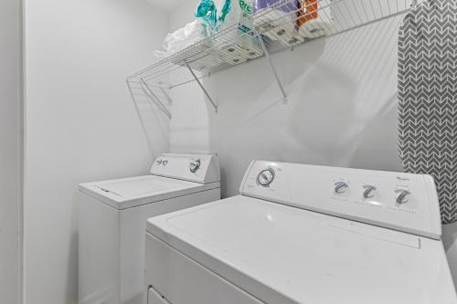 a white laundry room with a washing machine and a drying rack at Chic 1BR Oasis Ideal Retreat near Six Flags in Austell