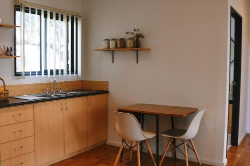 a kitchen with a sink and a table and chairs at Cosy Cottage in Geraldton - "Moresby Rest" in Bluff Point