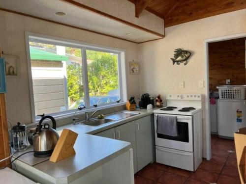 Dapur atau dapur kecil di Beautiful Te Ngaere Beach two bedroom bach with spa pool
