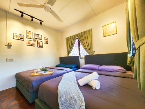 two beds in a room with purple beds at IPOH Rainbow Blissful Villa, Persiaran Halaman Ampang Ipoh in Ipoh