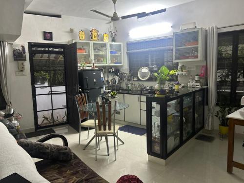 eine Küche mit einem Glastisch in einem Zimmer in der Unterkunft Chaithritha Ladies Homestay in Thiruvananthapuram