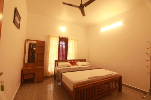 a bedroom with a bed and a mirror in it at Periyar Homes Plantation Stay in Thekkady