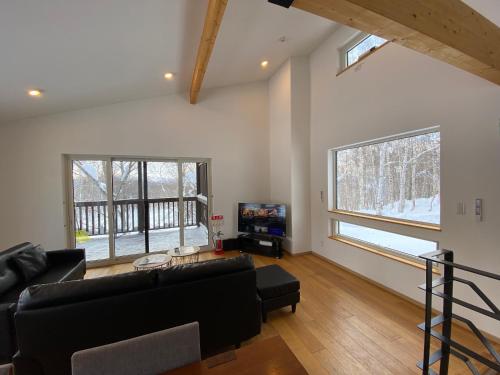 a living room with a couch and a tv at Yuki Kawa in Niseko