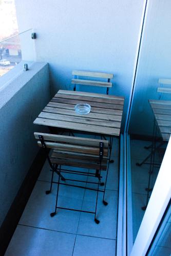 a wooden table and a bench in a room at Departamento céntrico Chillán con estacionamiento in Chillán