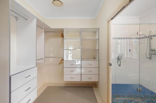 a bathroom with white cabinets and a shower at Luxury Range Stay! 6 Bedroom 4 Bathroom in Thornlands